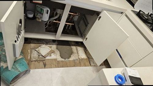 누수탐지 싱크대 하부 벽면에 생긴 물자국을 점검하는 장면