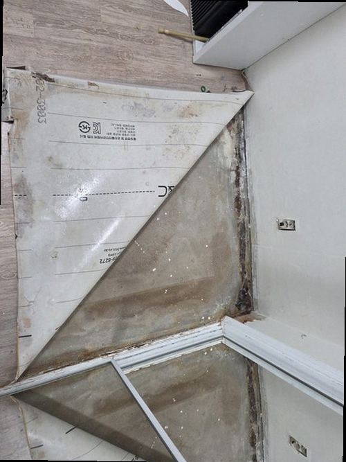 누수탐지 베란다 바닥 모서리에서 마감재가 들뜬 모습을 점검하는 장면