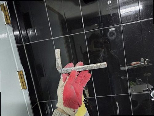 누수탐지 욕실 벽면 하단에 생긴 물얼룩을 살펴보는 점검 장면