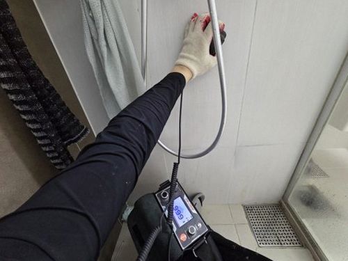 누수탐지 처치 후 건조된 욕실 바닥과 정리된 배관 점검구