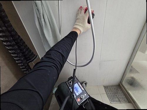 누수탐지 욕실과 맞닿은 벽면의 얼룩 및 마감재 변화를 살피는 모습