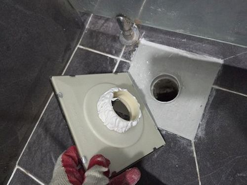 누수탐지 욕실 벽면 하단에 번진 누수 얼룩을 점검하는 모습