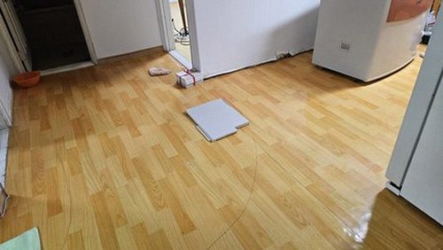 누수탐지 거실 벽면 얼룩과 바닥 상태를 살펴보는 점검 장면