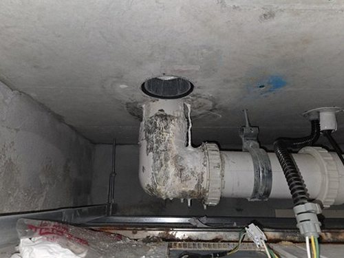 누수탐지 싱크대 하부장 바닥의 물기 흔적과 벽지 들뜸 상태를 확인하는 점검 장면