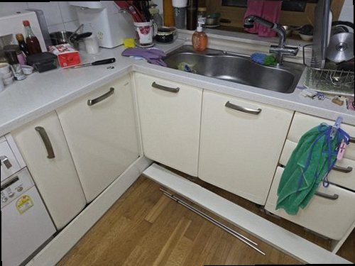 누수탐지 싱크대 하부 수납장과 급수·배수 연결부를 확인하는 모습