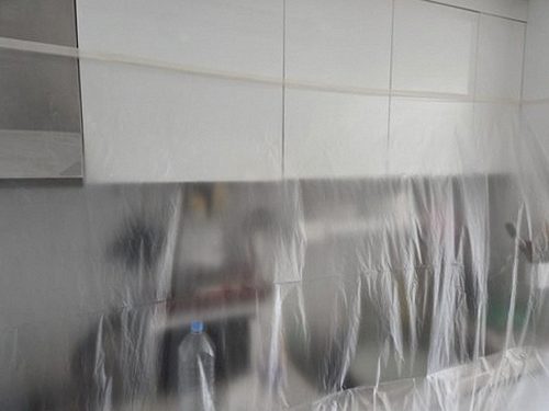 누수탐지 배관 보수 후 싱크대 하부와 벽면 상태를 재확인하는 모습