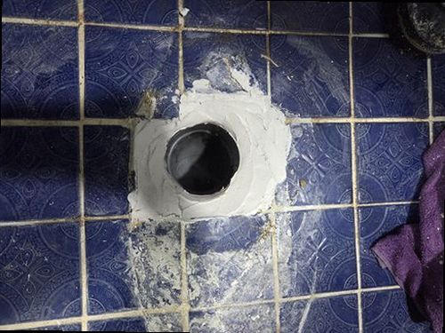 누수탐지 욕실 천장 점검 구멍 주변을 살피는 작업 장면
