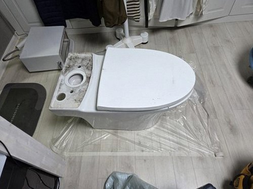 누수탐지 계량기와 배관 점검 장비가 놓인 욕실 점검 장면