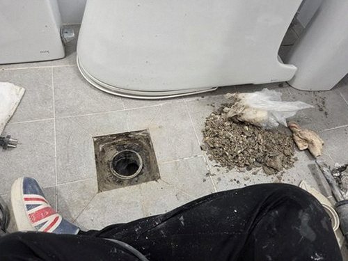 누수탐지 욕실 배관 주변의 얼룩과 습기 흔적을 점검하는 모습