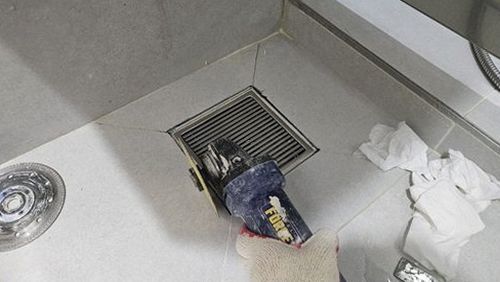 누수탐지 점검 장비로 배관 상태를 확인하는 작업자의 손