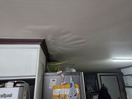 누수탐지 천장 가장자리에 번진 물자국과 벽지 들뜸을 확인하는 모습