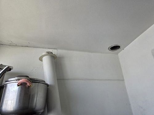 누수탐지 싱크대 하부장 배관 연결부와 벽면 얼룩을 점검하는 장면