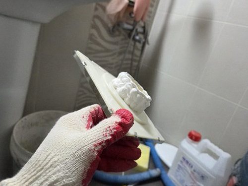 누수탐지 욕실 벽면 얼룩과 타일 줄눈 변색을 살펴보는 모습