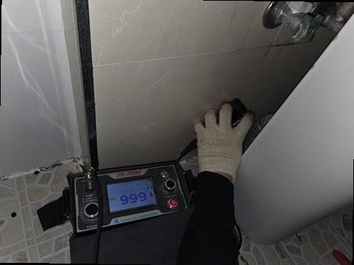 누수탐지 욕실 천장 모서리의 얼룩을 살피는 점검 장면