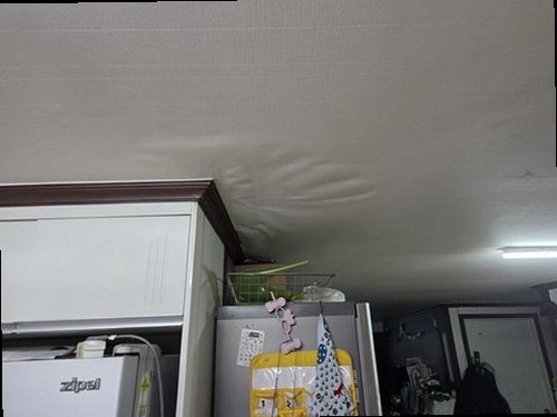 노원구 누수탐지 천장 모서리에 번진 얼룩과 주변 벽지 상태를 확인하는 모습