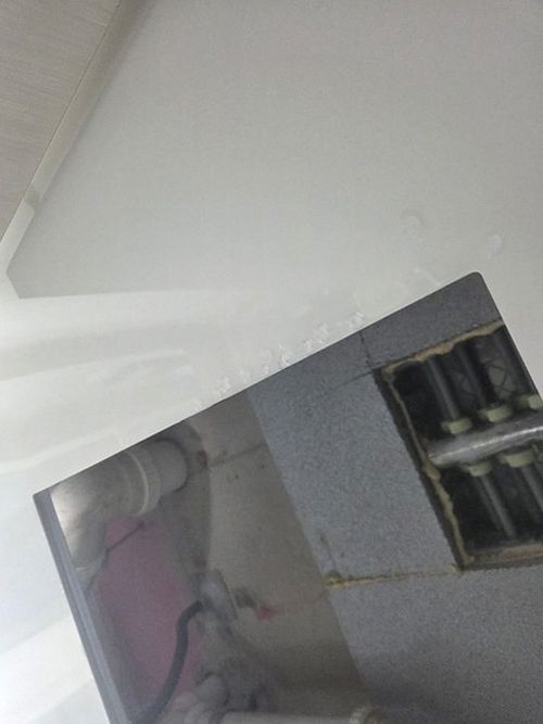 누수탐지 욕실 바닥 모서리에 나타난 습기 얼룩 관찰 장면