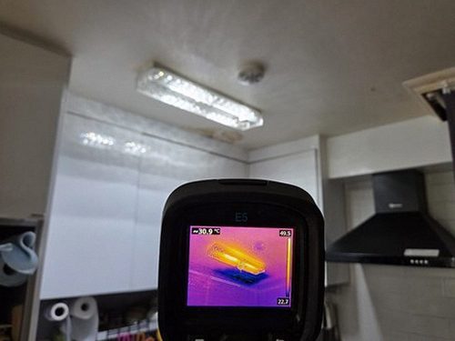 누수탐지 벽면 얼룩 주변을 수분 측정기로 점검하는 장면