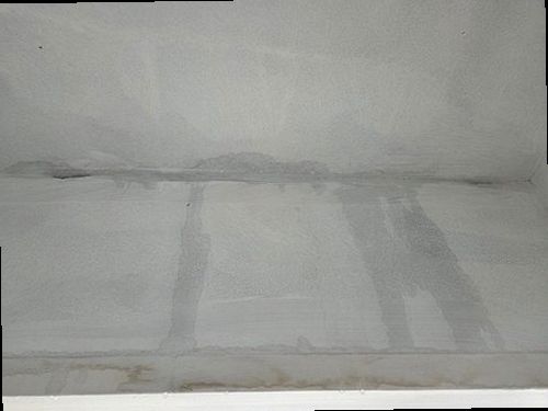 누수탐지 거실 천장과 벽면 경계에 생긴 얼룩을 점검하는 모습