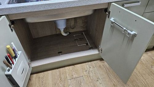 누수탐지 배관 이음부를 점검하는 작업자의 손과 측정 장비