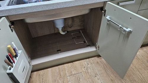 누수탐지 주방 벽지 들뜸 부위와 싱크대 하부를 살피는 점검 장면