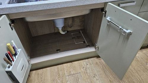 누수탐지 벽지 하단 얼룩과 싱크대 하부 배관을 점검하는 모습