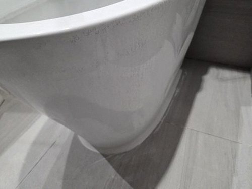 누수탐지 보수 후 건조된 욕실 바닥과 정리된 배관 점검구