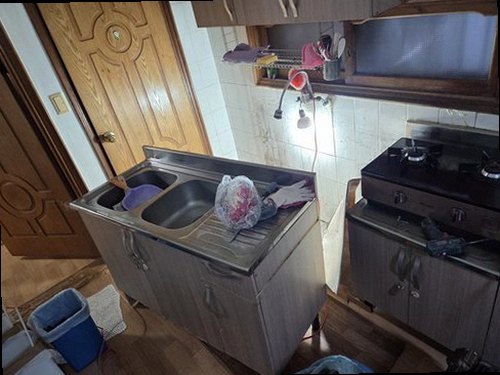 누수탐지 보수 후 싱크대 하부와 벽면의 건조 상태를 확인하는 모습