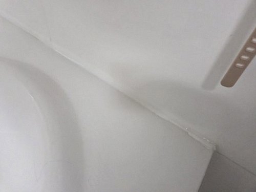 누수탐지 거실 천장 가장자리에 번진 얼룩을 살펴보는 모습