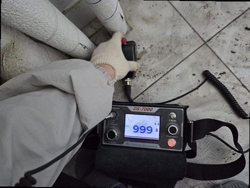 누수탐지 바닥 점검을 위해 음향 장비를 배관 라인에 대고 소리를 확인하는 장면
