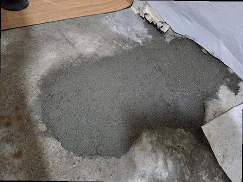 종로구 누수탐지 거실 벽지에 번진 물자국과 벽 아래쪽 상태를 살피는 장면