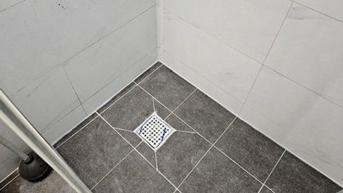 누수탐지 보수 후 욕실 배수 상태와 주변 마감의 건조 여부를 확인하는 장면