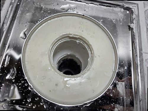 누수탐지 수분 측정기로 싱크대 주변 벽면과 바닥의 습도를 확인하는 장면