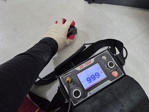 누수탐지 벽 속 배관 점검을 위해 장비를 대는 작업 장면