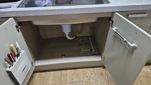 누수탐지 싱크대 하부장 안쪽과 벽면의 물기 흔적을 확인하는 모습