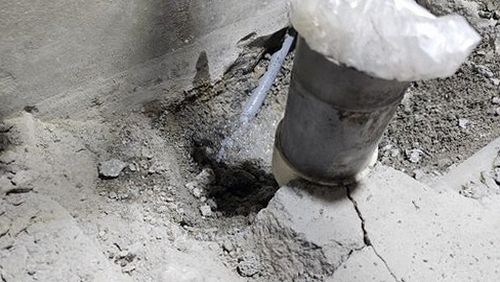 누수탐지 수도 계량기 표시와 주변 배관을 확인하는 모습