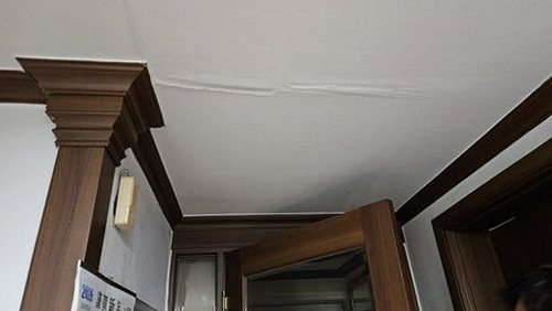 누수탐지 보수 후 아랫집 천장의 건조 상태를 측정하는 장면