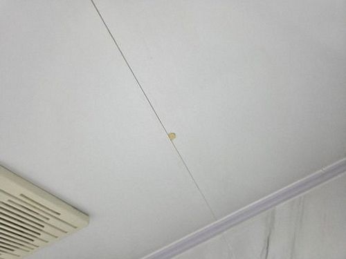 누수탐지 수리 뒤 거실 바닥과 벽체의 건조 상태를 확인하는 모습