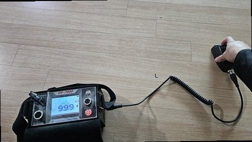 수영구 누수탐지 욕실 배관 아래 수납장을 열어 얼룩 흔적을 살피는 장면