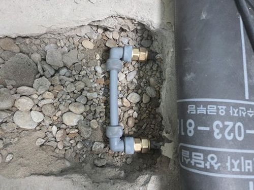 누수탐지 배관 경로 확인을 위해 벽면 마감 위에서 장비를 이동하며 점검하는 장면