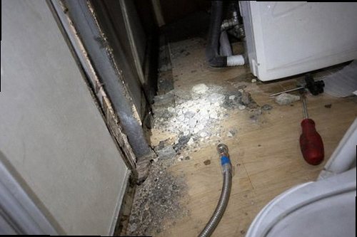 용산구 누수탐지 싱크대 하부장과 주방 바닥의 누수 흔적을 확인하는 모습